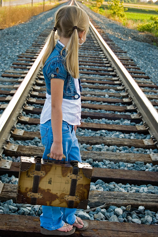Klein met valies op spoor
